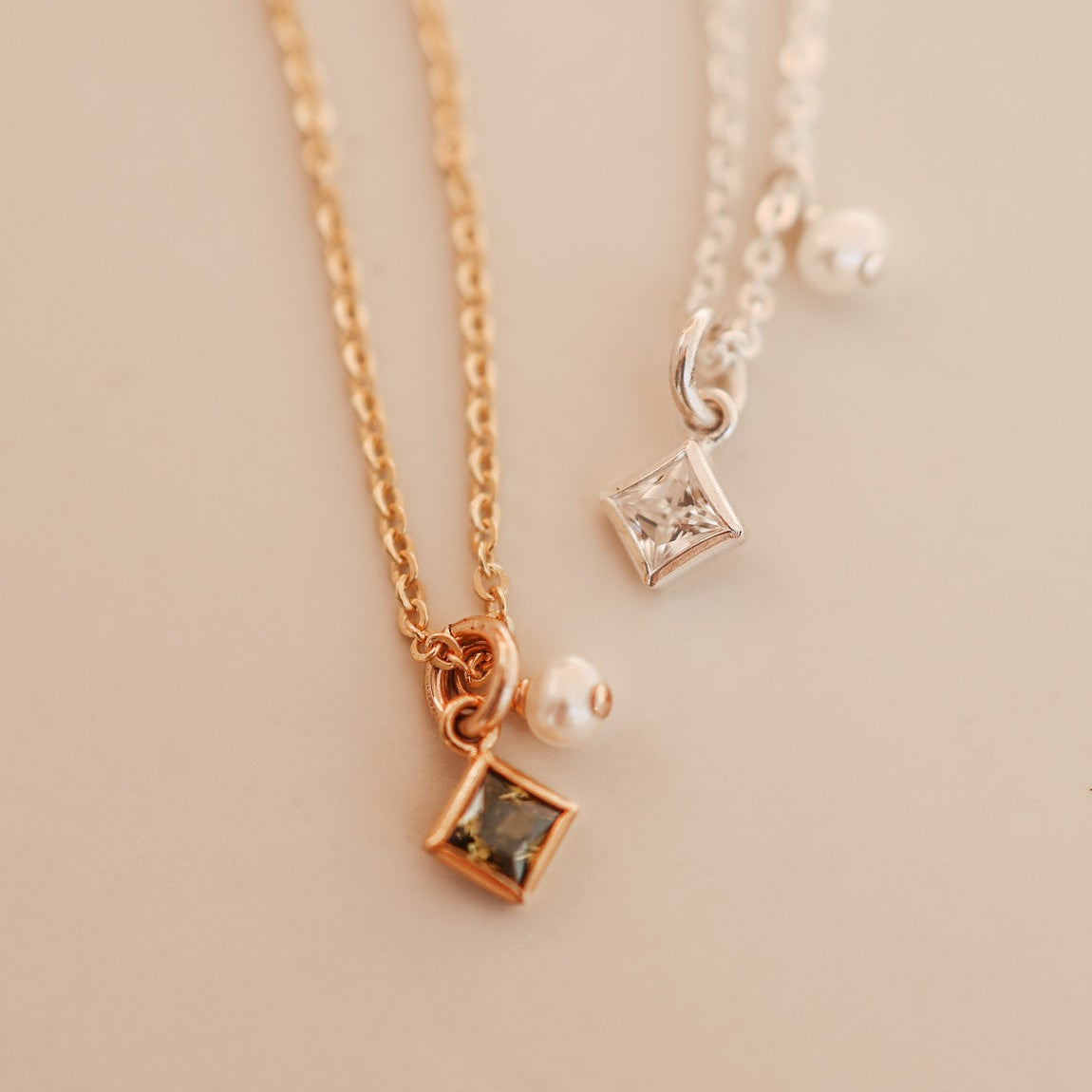 Two necklaces with square pendants on a light background - KBN Jewellery - Birthstone Necklace - Pearl Necklace