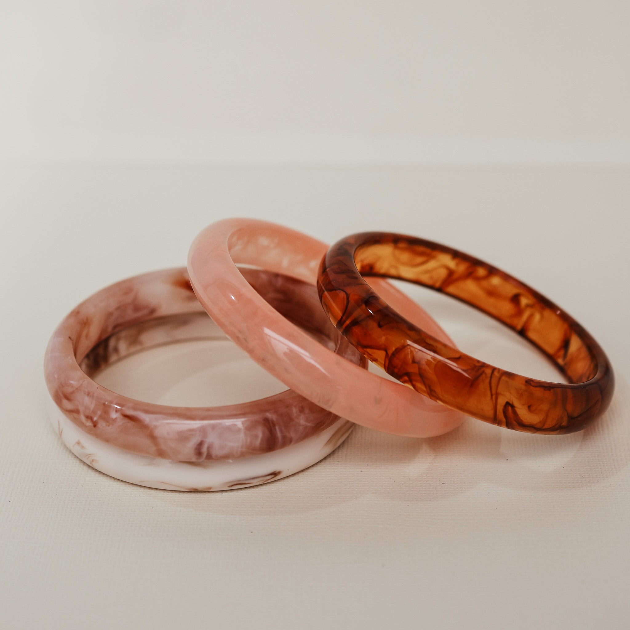 Three bangles in pink, white, and brown on a light background - KBN RESIN BANGLES