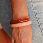 Person wearing two bangles on a wrist with a denim background - KBN RESIN BANGLES